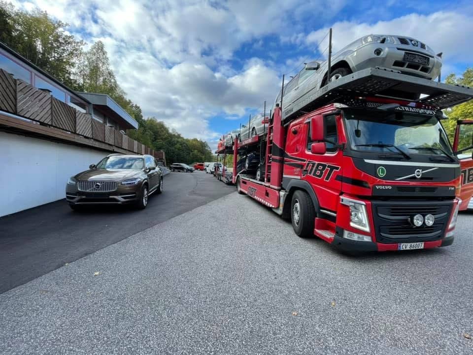 Biltransporter lastet med biler utenfor lokalet